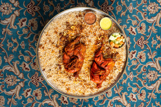 Flat lay of chicken fried mandi with vegetables and sauces