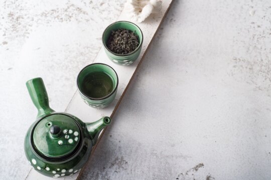 Flatlay of a green teapot and cups filled with herbal infused drink
