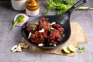 Mutton ghee roast dish served in a black casserole plate