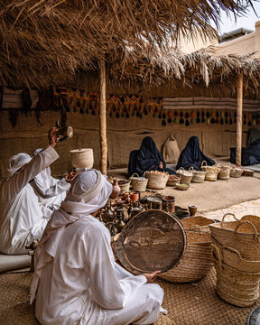 Men and women sitting on the ground selling hand-made baskets
