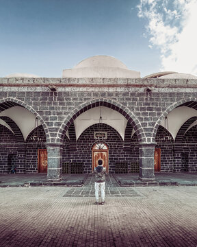 Person standing in front of Masjid Al Ghamamah