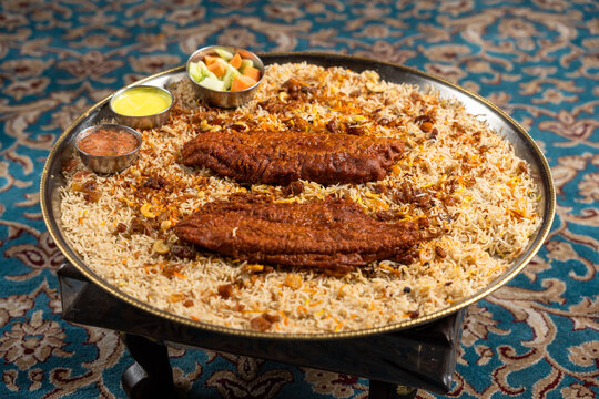 Platter of fried fish mandi with sauces and vegetables