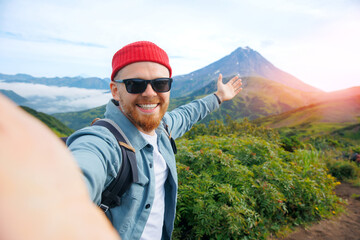 Naklejka premium Adventure action photo, traveler man make selfie on background Vilyuchinsky volcano, trip Kamchatka Russia
