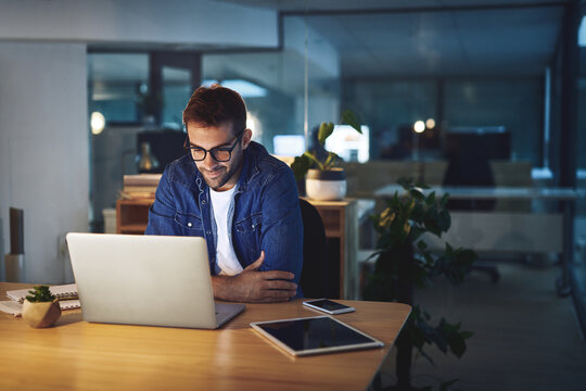 Night, reading and man at desk with laptop, business planning or checking email at digital agency. Thinking, dark and consultant on web design report with computer, ideas or online research in office