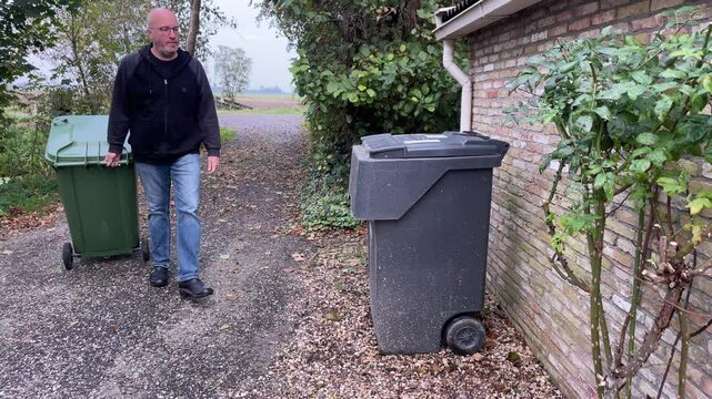Man Taking Garbage Bin from the Curb
