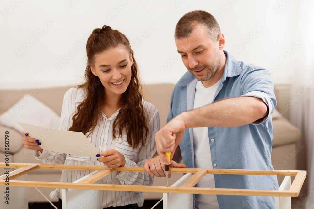 Poster happy couple installing wooden shelf following self-assembly manual instruction and using screwdrive