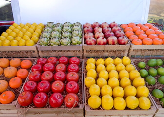 Fresh produce, fruits and vegetables, in display crates on the back of a truck for sale at a farmers market