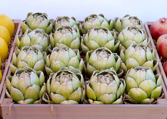 Close up on crate of fresh artichoke on display at farmers market