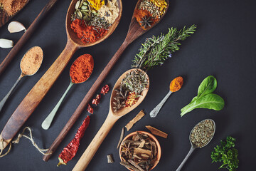 Kitchen, curry and spices with spoon for culinary ingredients, flavor and seasoning on counter for cooking. Seeds, leaves and above table for meal prep, herbs and variety for food at restaurant