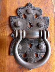 Door knocker. Vintage design knocker on the wooden doors for knocking. Vertical view
