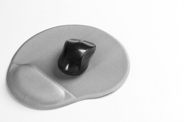 Computer mouse and mousepad with armrest on white table, space for text