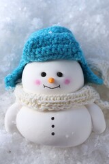 Fototapeta premium Cute decorative snowman on artificial snow, top view