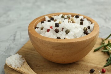 Sea salt and spices in bowl on gray table, closeup