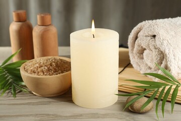 Spa composition with burning candle on wooden table