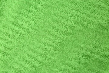 Fototapeta premium Clean green microfiber cloth as background, top view