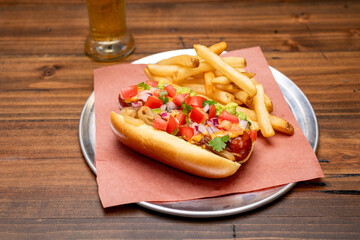 Gourmet Hot dog on a tray with a beer and french fries