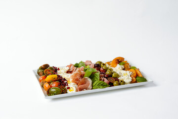 Cured meats, eggs, olives cheese and fresh herbs on a platter