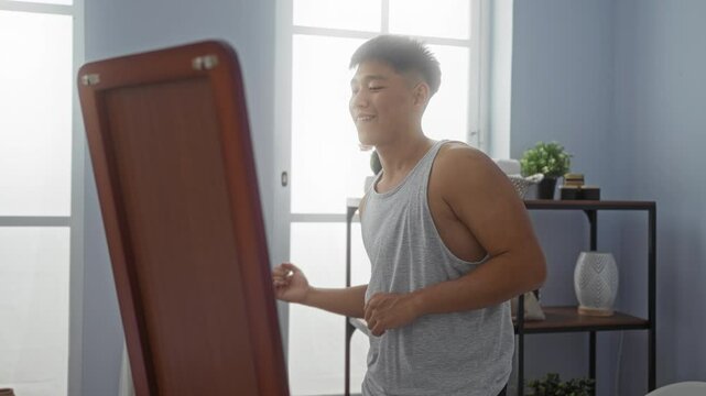 Young man practicing dance moves in front of a mirror in a wellness center with a relaxed and determined expression