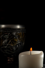 Lighted candles, scene with various objects and recently extinguished candles. Selective focus.