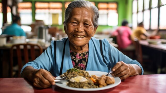 A joyful elderly woman sits at a table with a hearty meal, radiating warmth and contentment in a bustling, colorful dining setting.