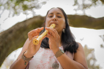 Woman practicing to play the flute in the park