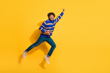 Full body photo of attractive young man hold device fly superman dressed stylish blue striped...