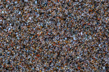 A close up of a sandy beach with a lot of rocks and pebbles