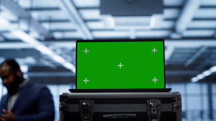 Green screen laptop used by engineers monitoring server room, doing checkup. Focus on chroma key notebook used by IT support employee working in data center facility, camera A close up