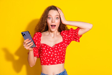 Naklejka premium Photo portrait of pretty young girl shocked hold device wear trendy red outfit isolated on yellow color background