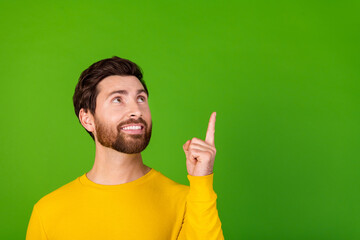 Photo portrait of handsome young guy point look up empty space dressed stylish yellow garment isolated on green color background