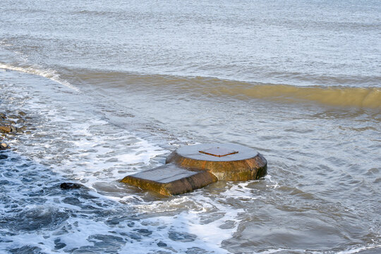 Concrete sewer pipes in the ocean leading to marine outfall into the sea potentially polluting the environment