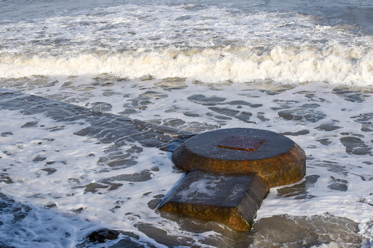Concrete sewer pipes in the ocean leading to marine outfall into the sea potentially polluting the environment