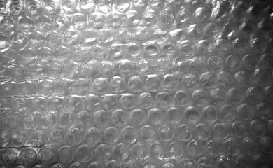 Bubble wrap, close-up background photo. It is a pliable transparent plastic material with bubbles of air used for packing fragile items