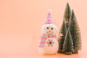 Merry christmas and happy new year decorated with old snowman and pine trees on pink background.