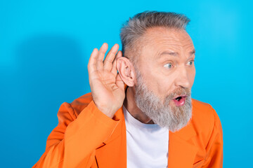 Photo of funny trendy aged man hand ear eavesdrop wear orange costume isolated on blue color...
