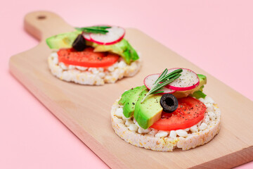 Rice Cake Sandwiches with Avocado, Tomato, Cottage Cheese, Olives and Radish on Wooden Cutting Board. Easy Breakfast. Diet Food. Quick and Healthy Sandwiches. Crispbread with Tasty Filling