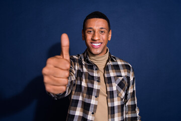Naklejka premium Photo portrait of attractive young man show thumb up approve dressed stylish checkered clothes isolated on dark blue color background