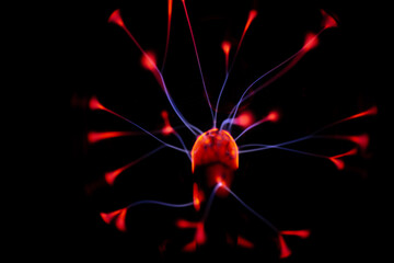 A glowing plasma ball with red and blue electric arcs radiating from its core against a dark...