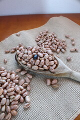 Carioca beans in a woooden spoon on the juta fabric. Brazilian cuisine.