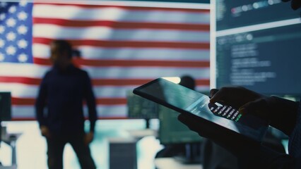Cybersecurity expert in a governmental IT environment with the American flag. Monitoring cybersecurity, encryption and data security on a tablet to protect against cyber threats. Close up. Camera B.