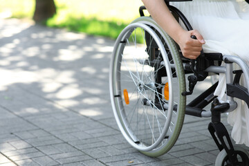 Naklejka premium Woman in wheelchair outdoors, closeup