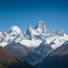 Obraz premium Majestic mountain range with snow-capped peaks under a clear sky