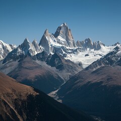 Obraz premium Majestic mountain range with snow-capped peaks under a clear sky
