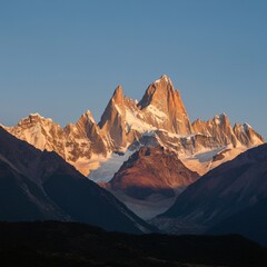 Fototapeta premium Majestic mountain range with snow-capped peaks under a clear sky