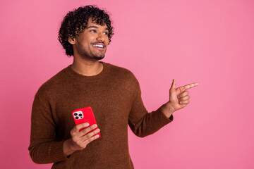 Photo of funny nice man wear stylish brown clothes hold device look empty space isolated on pink color background