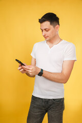 man looking at watch and phone on yellow.
