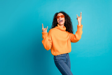 Photo of shiny attractive young lady dressed knitted pullover showing hard rock signs empty space isolated blue color background