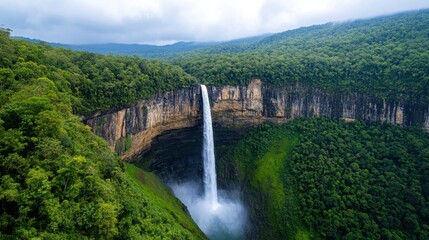 Obraz premium Majestic Waterfall Plunging into Misty Valley