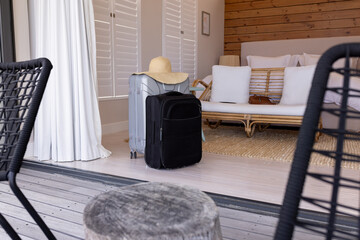 Suitcases with sun hat in cozy bedroom, ready for holiday travel, at home