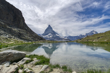 Alpine lake in Swiss mountains, Matterhorn over dramatic sky and water